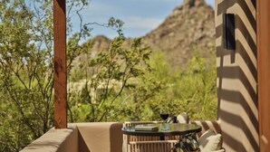 A balcony with a table, a glass of red wine, and a book. - 2-bedroom Resort in soothing Scottsdale with AC and fitness room (Scottsdale)
