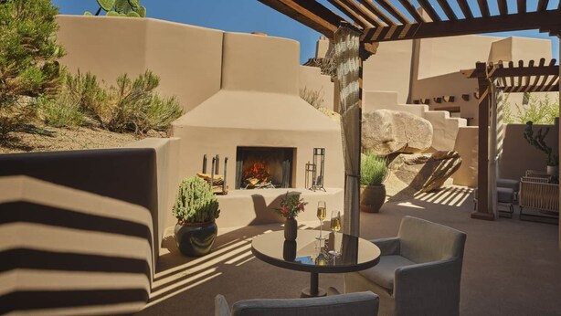 An outdoor patio with a round table, chairs, a fire pit, and potted plants. - 2-bedroom Resort in soothing Scottsdale with AC and fitness room (Scottsdale)