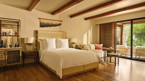 A bedroom with a large bed, a desk with a lamp, a chair, and a view of greenery outside. - 2-bedroom Resort in soothing Scottsdale with AC and fitness room (Scottsdale)