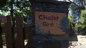 A stone pillar with a mosaic sign reading 'Chalet Gré' and a wooden gate. - Chalet Gré, between greenery and Cevennes mountains (LE POMPIDOU)