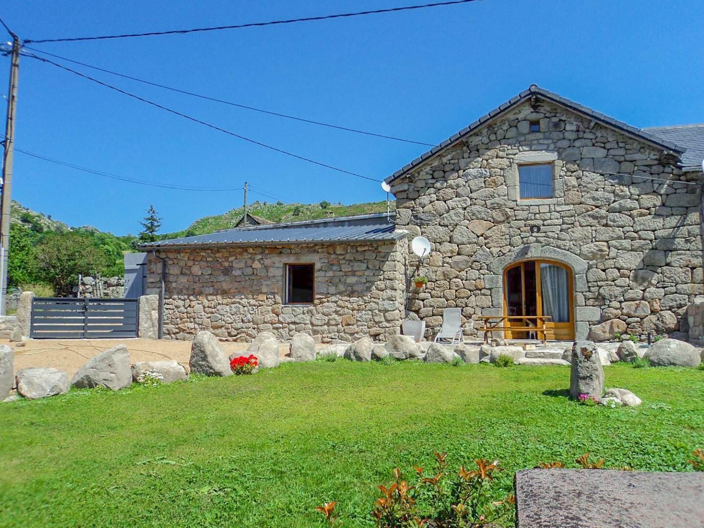 Un edificio de piedra con puerta de madera, una ventana pequeña y una antena parabólica.