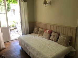 Una camera da letto con un letto, un comodino, una lampada e una finestra con tende.