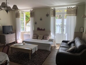 Ein Schlafzimmer mit einem Bett, einem Fernseher, einer Couch und einem Esstisch.