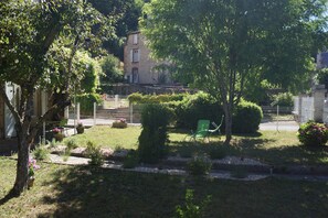 Ein Garten mit Rasenfläche, einem grünen Stuhl und einem Zaun.