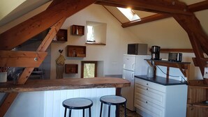 Een landelijke keuken met houten balken, een bar en een gezellig zitje.