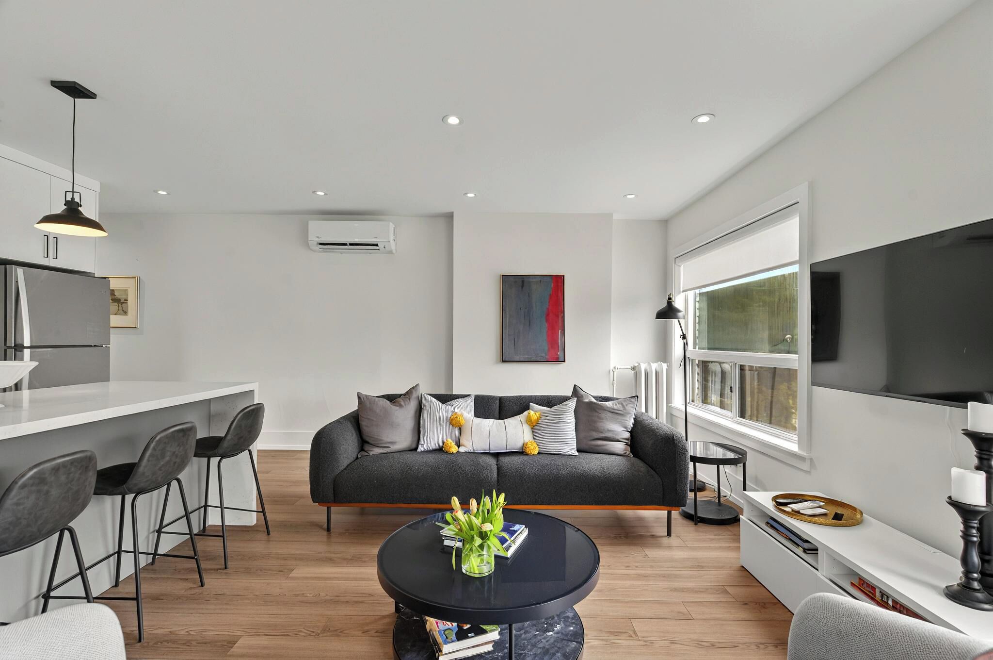 A modern living space with a kitchen, dining area, and seating area.