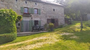 A stone building with a small patio and outdoor seating. - LA DROSERA - LAJO - Gîte (LAJO)