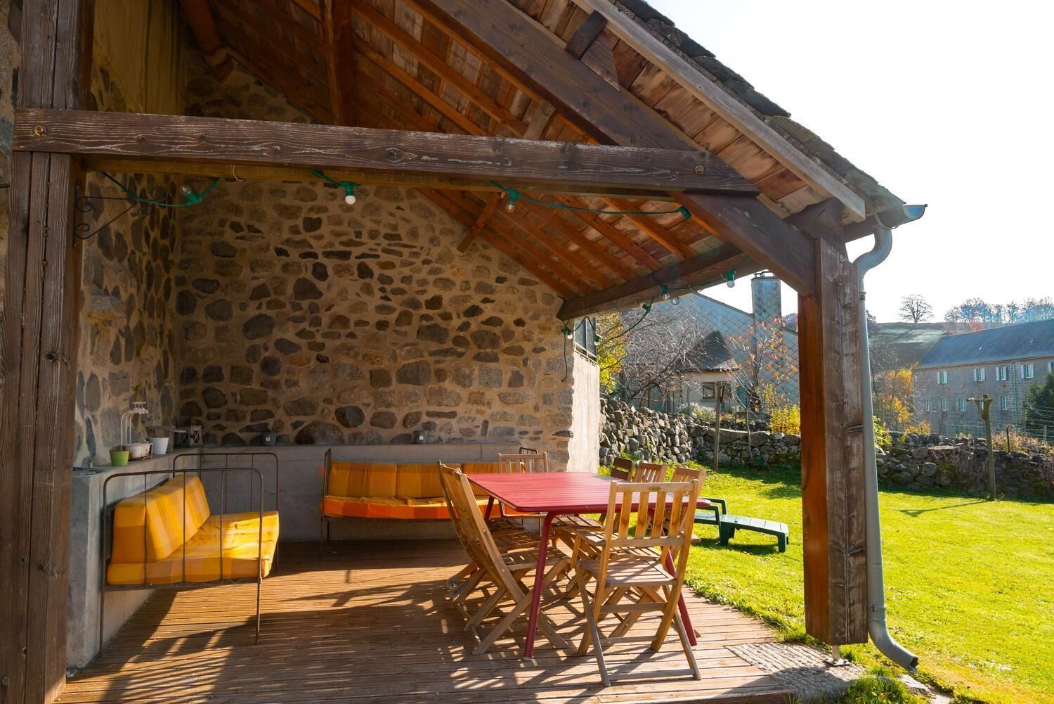 Una habitación con paredes de piedra, un banco de madera, una mesa y sillas.