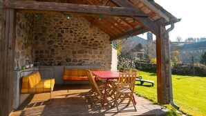 Una habitación con paredes de piedra, un banco de madera, una mesa y sillas.
