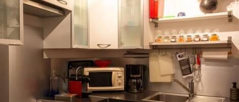 Una cocina moderna con electrodomésticos de acero inoxidable, armarios blancos y horno empotrado.