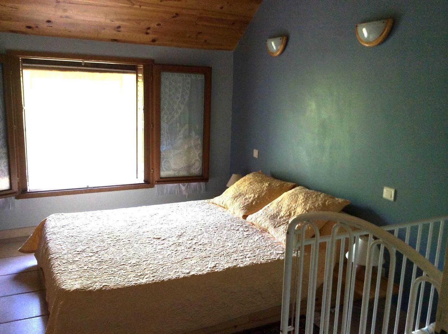 Una camera da letto con un letto, una finestra e una culla.