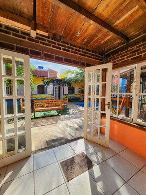 An open doorway leading to a patio area with a bench and a hammock.