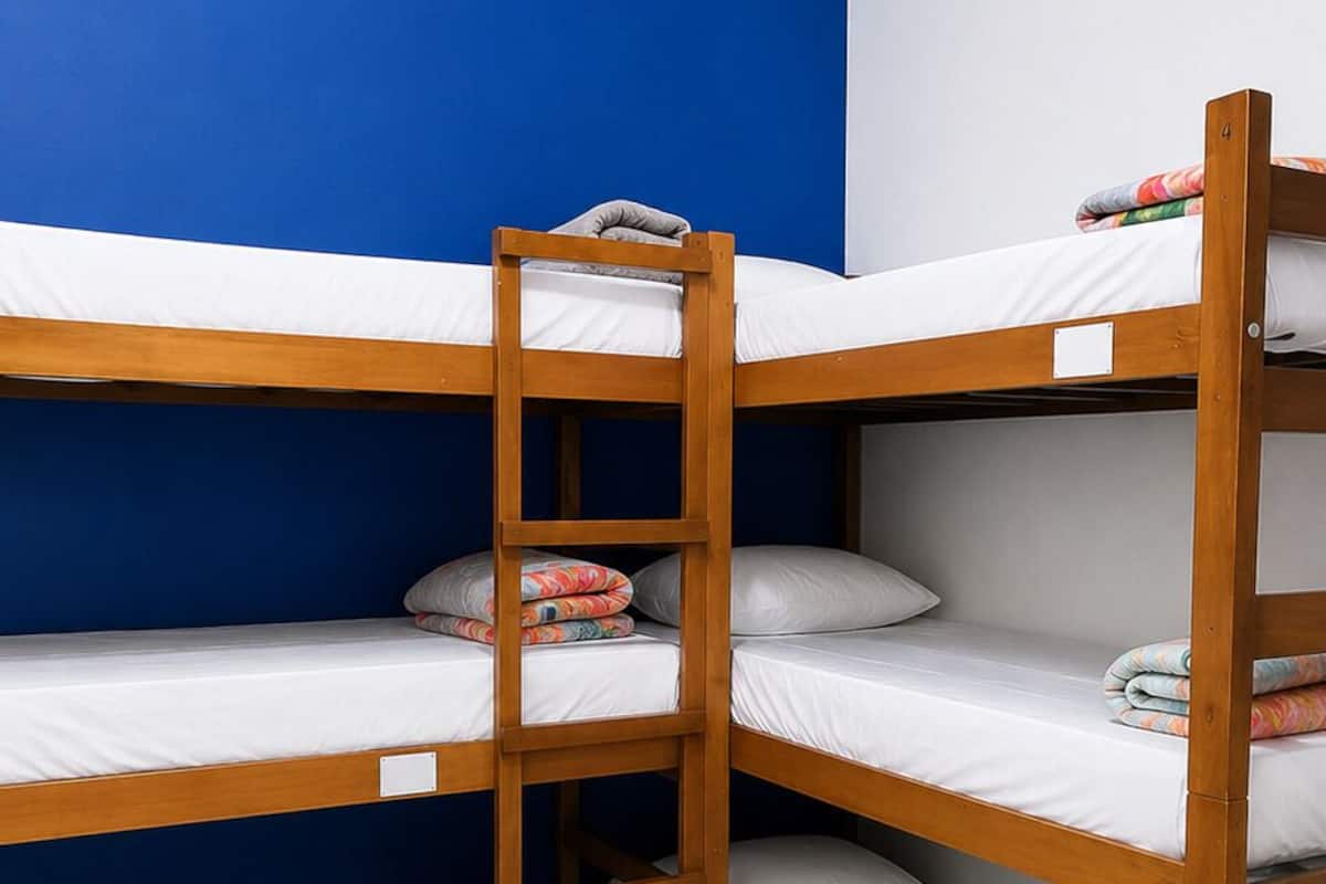 Dormitorio con literas, paredes azules y techo blanco.