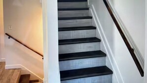 Eine Treppe mit Holzgeländer und einer strukturierten Wand.