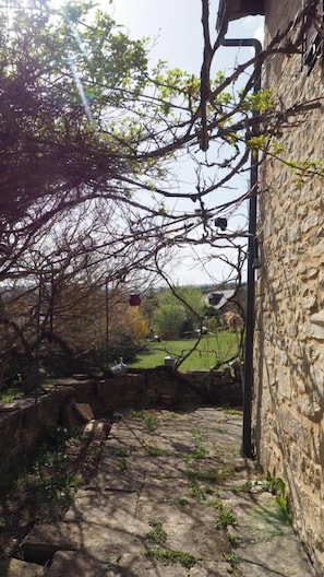 A stone building with a narrow stone pathway leading to a grassy area. - La Maisonnette - MARVEJOLS (MARVEJOLS)