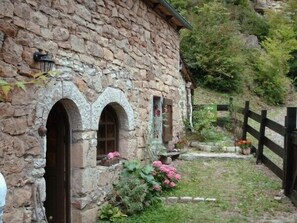 Ein Steinhaus mit Bogenfenstern und einem Holzzaun.