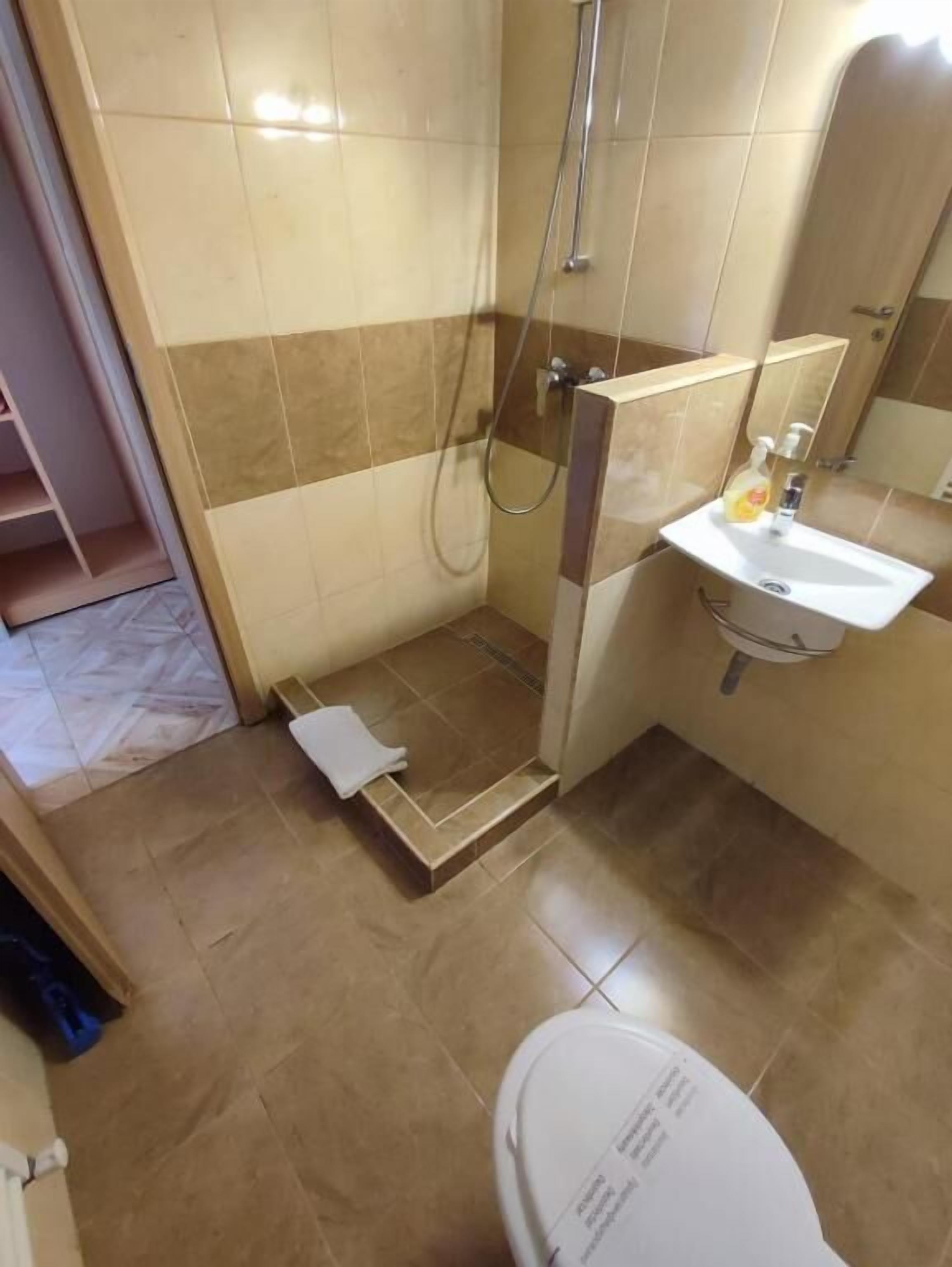 A bathroom with a shower, sink, and toilet.