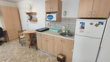 Estudio económico, patio | Cocina privada | Frigorífico pequeño, microondas, placa de cocina y utensilios de cocina