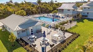 Ein Wohnhaus mit Swimmingpool, Terrassenmöbeln und einem gepflegten Rasen.