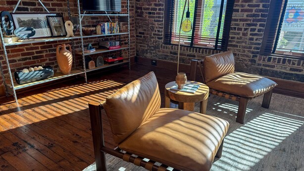 A cozy room with leather sofas, a bookshelf, and a brick wall. - Historic Media Loft in Downtown Columbus - Newly Renovated - Walk Everywhere (Columbus)