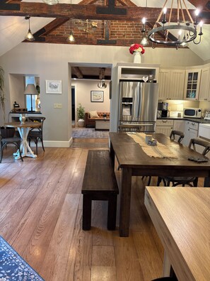 Une cuisine spacieuse dotée d’un îlot central, de planchers en bois et d’appareils électroménagers modernes.