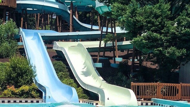 Parque acuático con múltiples toboganes y una zona de piscina.