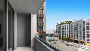 A balcony with a view of a parking lot and a building with multiple windows and balconies. - Luxury Wynwood Studio with Amenities in Miami (Miami)