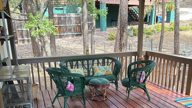 Eine Holzterrasse mit Korbmöbeln und einem Metalltisch.
