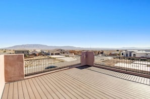 Eine Dachterrasse mit freiem Blick auf eine Wohngegend und entfernte Berge.