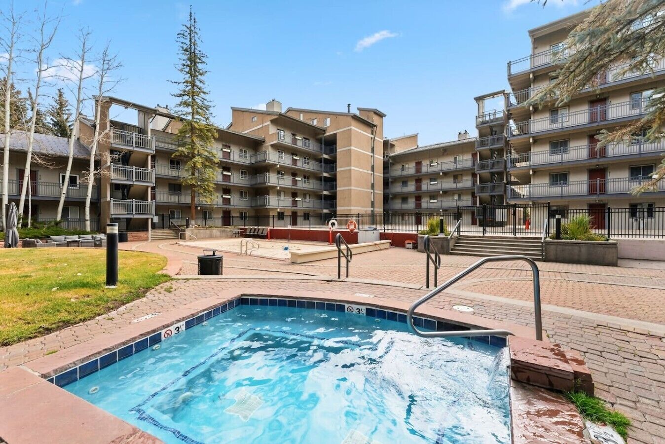 En bostadsbyggnad med en swimmingpool, balkonger och ett välanlagt område.