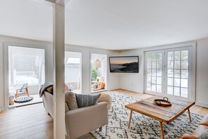 Ein Wohnzimmer mit einer Couch, einem Couchtisch und einem großen Fenster mit Blick.