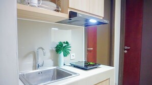 Een keuken met een RVS spoelbak, een moderne afzuigkap en een digitale weegschaal op het aanrecht.