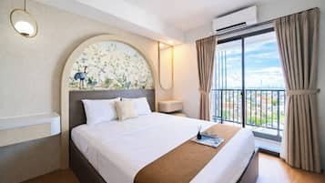 Quarto de hotel com uma cama grande, vista para a cidade e ar condicionado.