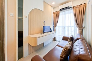 Ein modernes Wohnzimmer mit einer Couch, einem Wand-Fernseher und einer eingebauten Regalanlage.