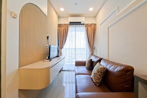 Uma sala de estar moderna com um sofá, uma TV e um banco embutido.