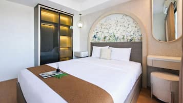 Quarto de hotel com cama, mesa de cabeceira, espelho, guarda-roupa e parede com um mural floral.