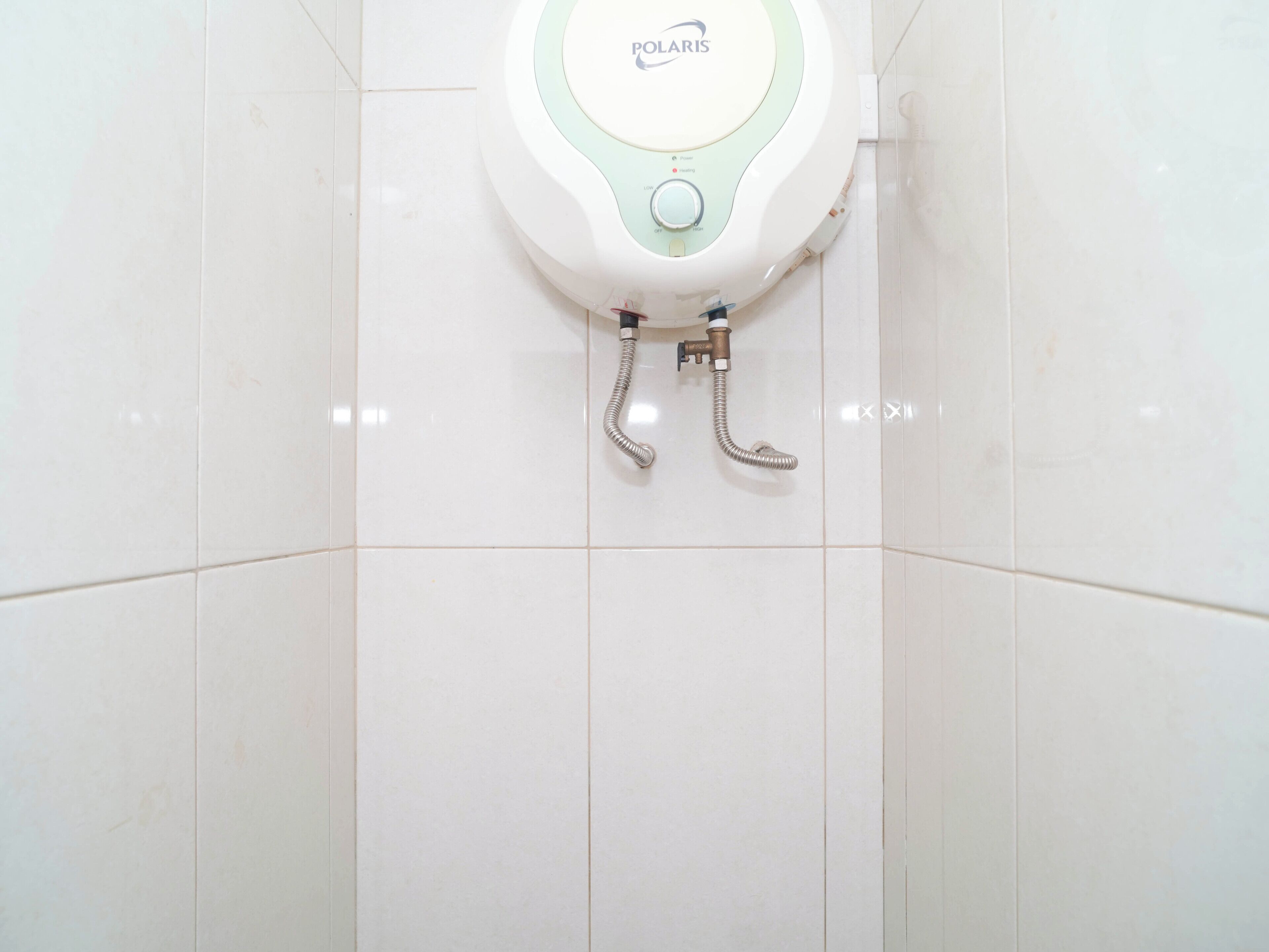 A toilet with a control panel labeled 'POLARIS' and a flexible hose.