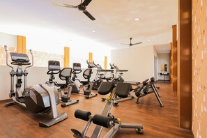 Ein modernes Fitnessstudio mit verschiedenen Trainingsgeräten, darunter Laufbänder, Ergometer und Kraftgeräte.