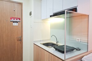Eine kleine Küche mit Spüle, Mikrowelle und einer Glaseinfassung.