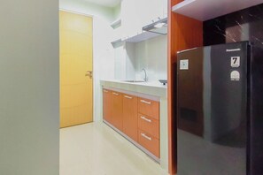 A kitchen with a refrigerator, cabinets, and a sink. - Convenient 2Br For 4 Pax At Bale Hinggil Apartment (Surabaya)