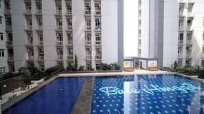 Una piscina con piso de baldosas azules y un letrero de neón que dice 'Bole House'.