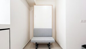 A narrow hallway with a grey bench and a white door. - Good Deal Studio (No Kitchen) Bandaraya - Tallasa City Makassar Apartment (Makassar)