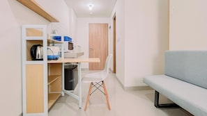 A compact living space with a kitchenette, a dining area, and a seating area. - Warm And Comfy Studio Apartment (No Kitchen) Bandaraya - Tallasa City Makassar (Makassar)