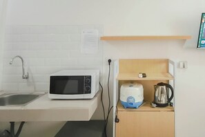 A kitchen with a microwave, kettle, and kettle on a shelf. - Studio (No Kitchen) Apartment With Murphy Bed At Bandaraya - Tallasa City Makassar (Makassar)