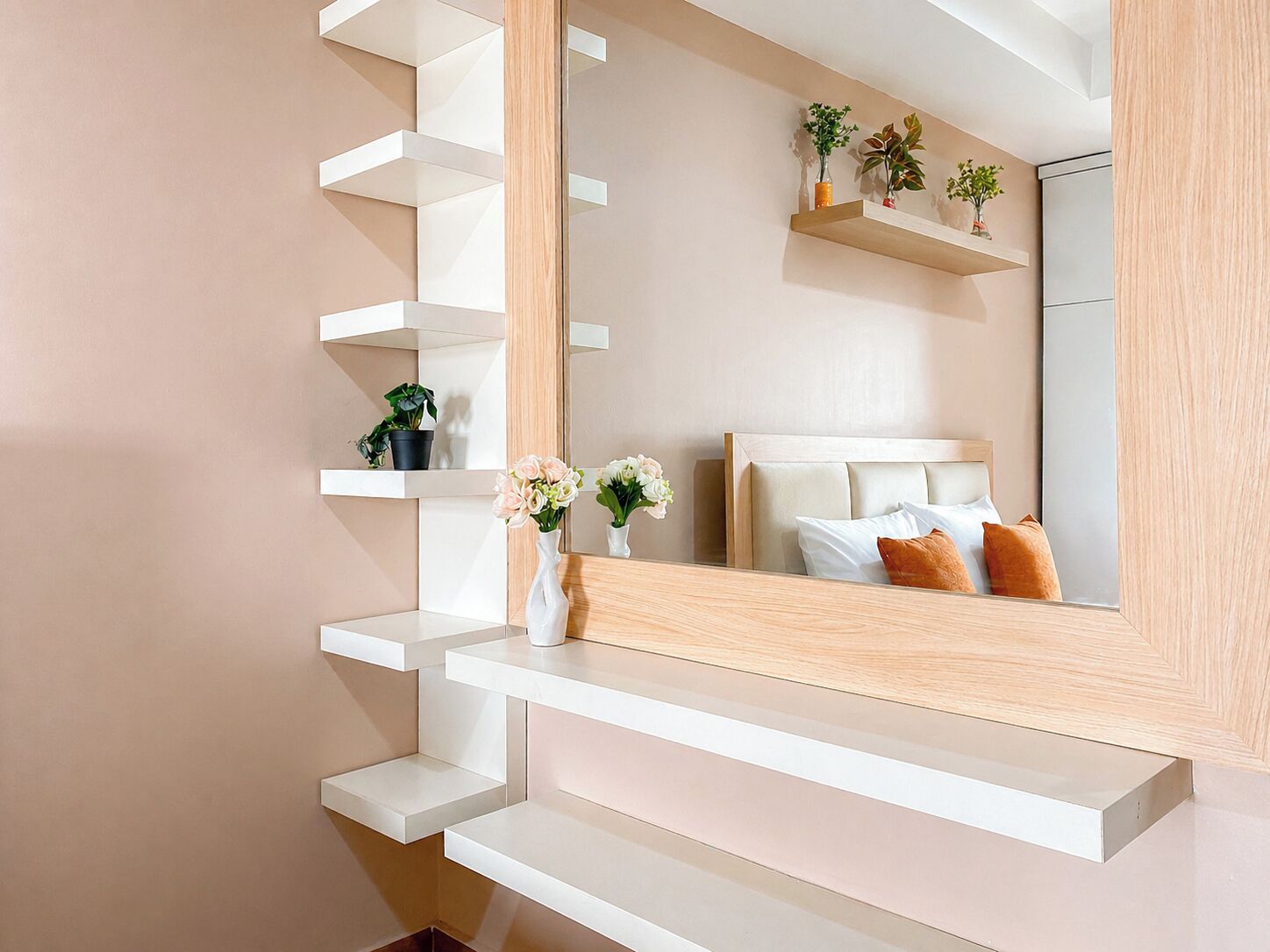 Ein modernes Schlafzimmer mit einem großen Spiegel, einem Bett mit weißer Bettwäsche und einer Holztreppe.