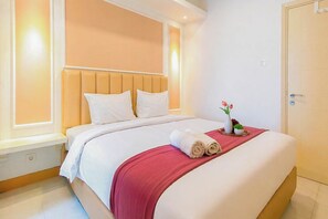 Ein Hotelzimmer mit Bett, Nachttisch, Fenster und Tür.