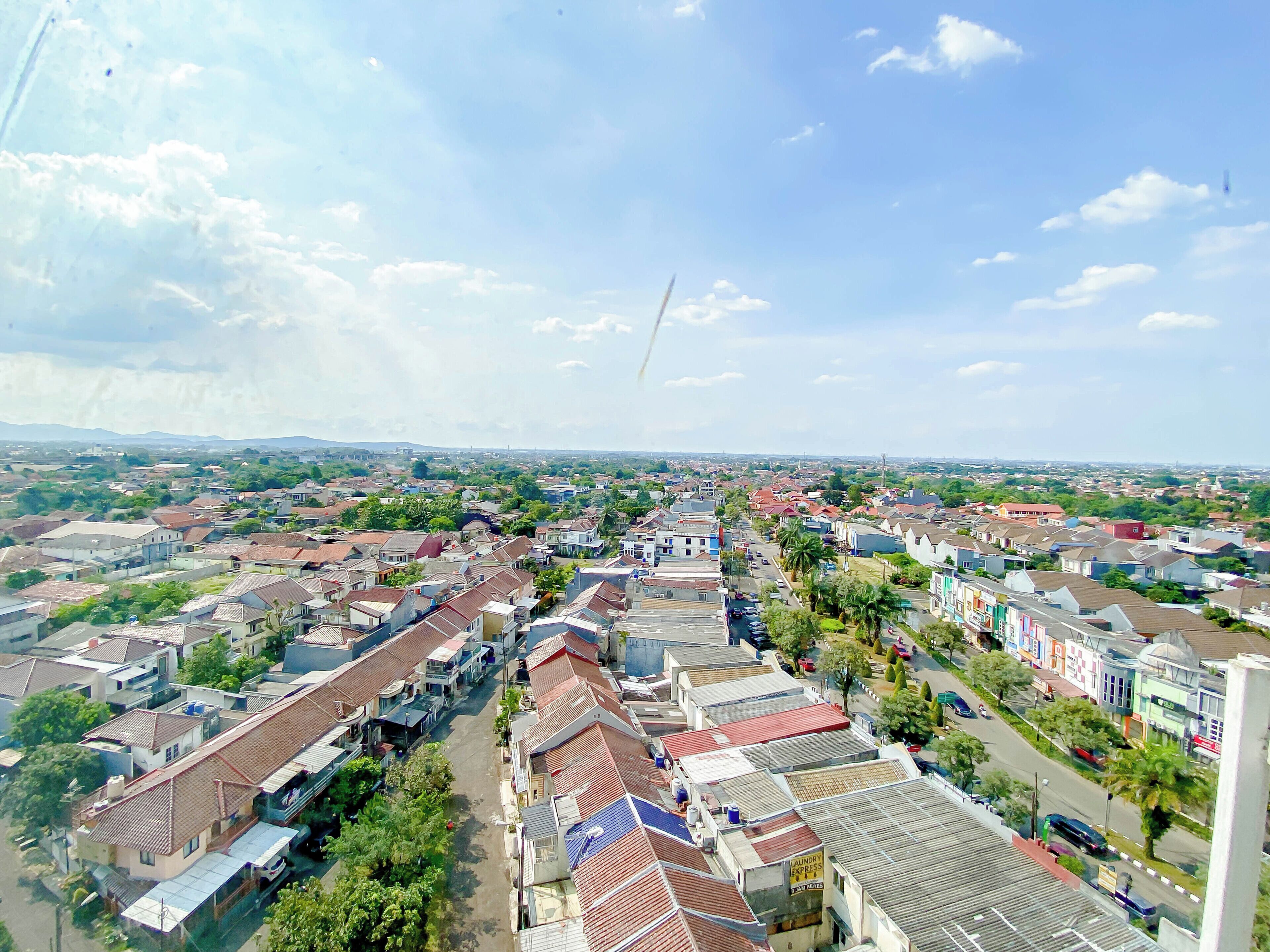 Un barrio residencial con casas, calles y una cadena montañosa a lo lejos.