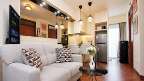 A living room with a sofa, a coffee table, and a decorative vase. - Neat And Homey 2Br Apartment Cinere Resort (Depok)