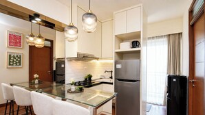 A modern kitchen with a glass island, stainless steel appliances, and pendant lighting. - Neat And Homey 2Br Apartment Cinere Resort (Depok)