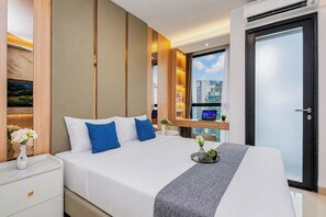 A modern hotel room with a bed, bedside table, and a view of the cityscape. - Charming Warm Studio At Ciputra World 2 Apartment (Jakarta)